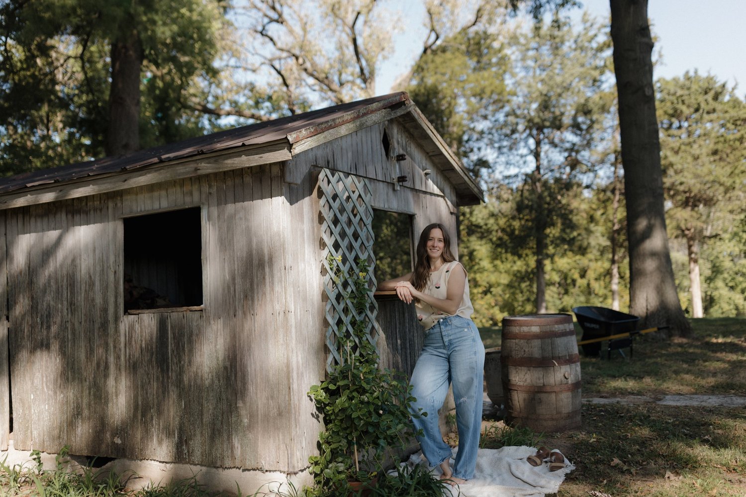 Ariel leaning on a weathered barn in the afternoon light